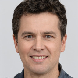 Joyful white adult male with short  brown hair and brown eyes