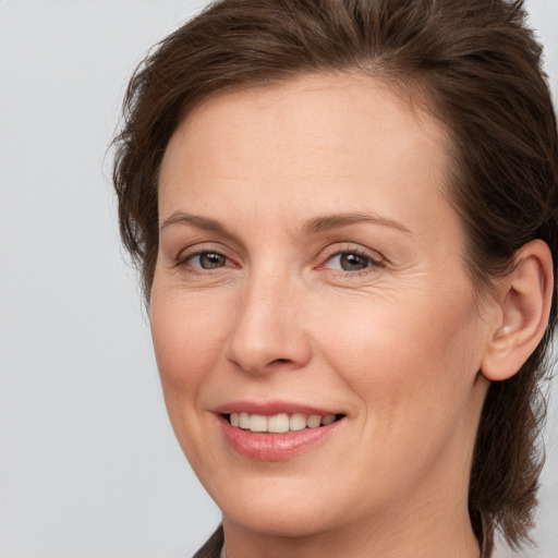 Joyful white adult female with medium  brown hair and brown eyes