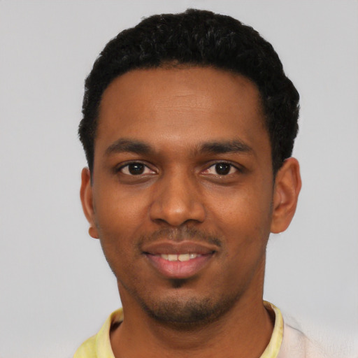 Joyful black young-adult male with short  black hair and brown eyes