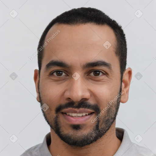 Joyful latino young-adult male with short  black hair and brown eyes