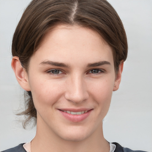 Joyful white young-adult female with short  brown hair and grey eyes