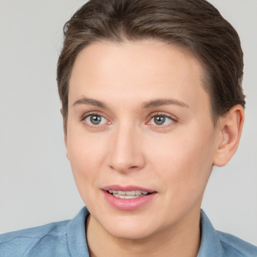 Joyful white young-adult female with short  brown hair and grey eyes