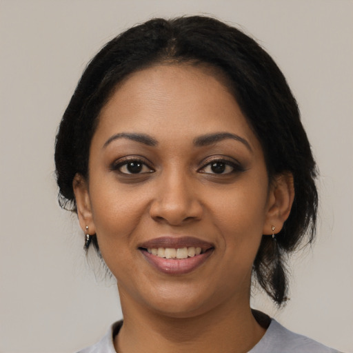 Joyful black young-adult female with medium  black hair and brown eyes