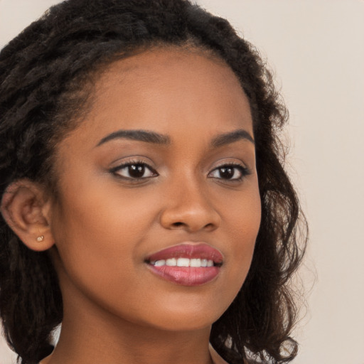 Joyful black young-adult female with long  brown hair and brown eyes