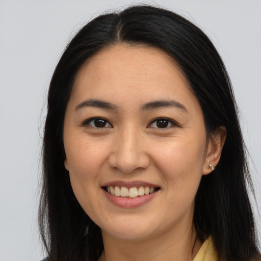 Joyful asian young-adult female with long  brown hair and brown eyes