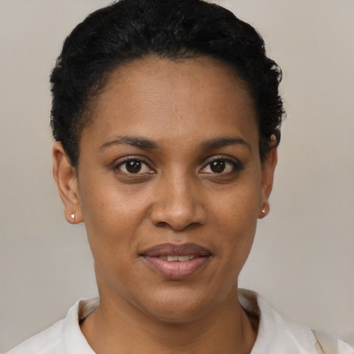 Joyful black young-adult female with short  black hair and brown eyes