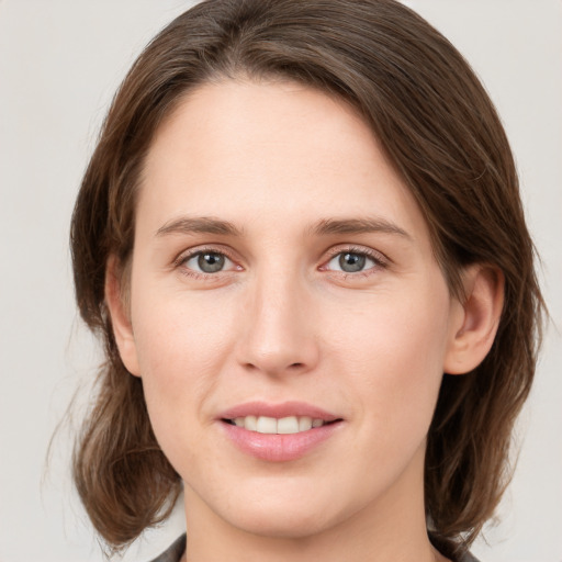 Joyful white young-adult female with medium  brown hair and green eyes