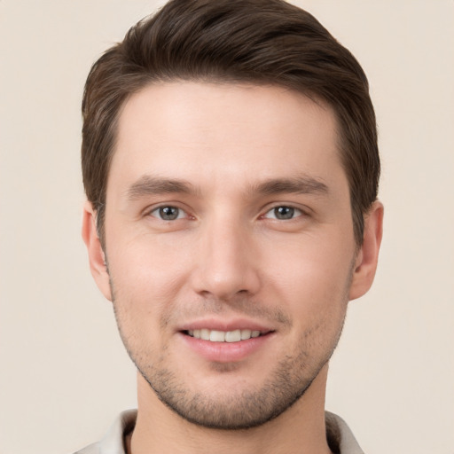 Joyful white young-adult male with short  brown hair and grey eyes