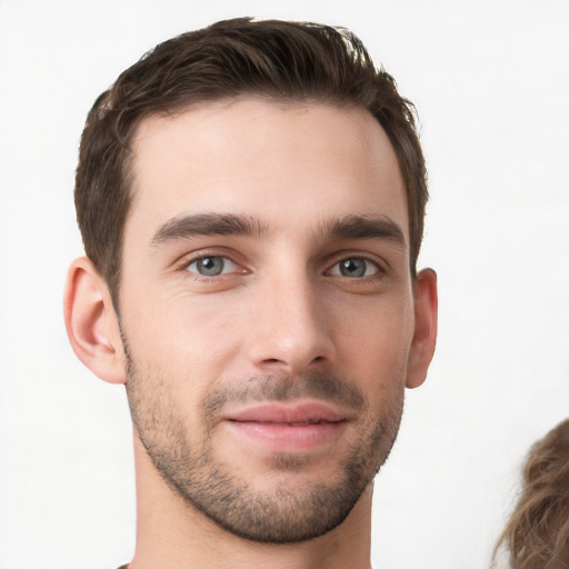 Joyful white young-adult male with short  brown hair and grey eyes