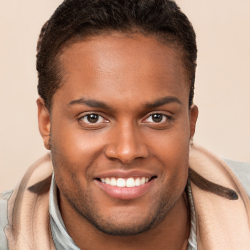 Joyful black young-adult male with short  brown hair and brown eyes