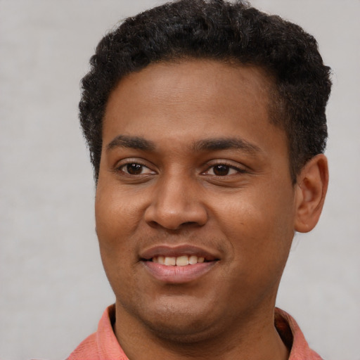 Joyful black young-adult male with short  brown hair and brown eyes