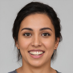 Joyful latino young-adult female with medium  brown hair and brown eyes