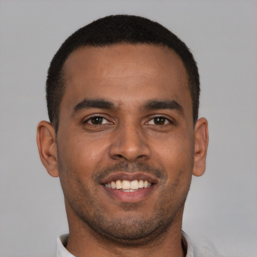 Joyful black young-adult male with short  brown hair and brown eyes