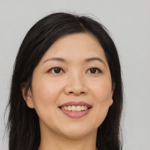 Joyful asian young-adult female with long  brown hair and brown eyes