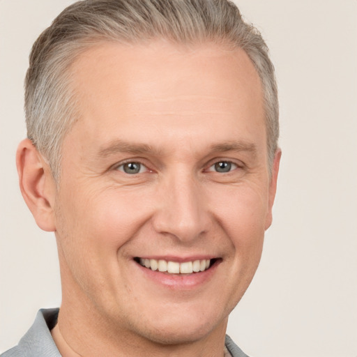 Joyful white adult male with short  brown hair and grey eyes