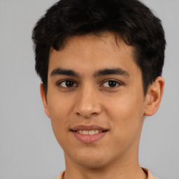 Joyful latino young-adult male with short  brown hair and brown eyes