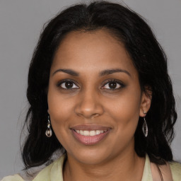 Joyful black young-adult female with long  brown hair and brown eyes