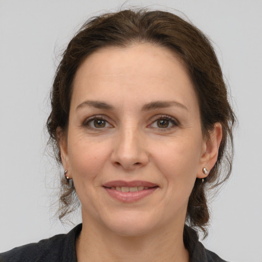 Joyful white adult female with medium  brown hair and grey eyes