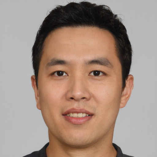 Joyful asian young-adult male with short  black hair and brown eyes