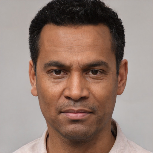 Joyful latino adult male with short  black hair and brown eyes