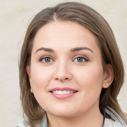 Joyful white young-adult female with medium  brown hair and green eyes