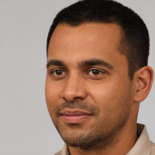 Joyful black young-adult male with short  black hair and brown eyes