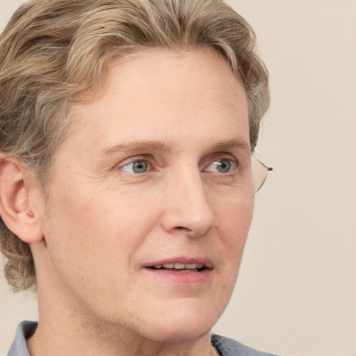 Joyful white adult male with medium  brown hair and blue eyes