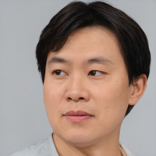 Joyful asian adult male with short  brown hair and brown eyes