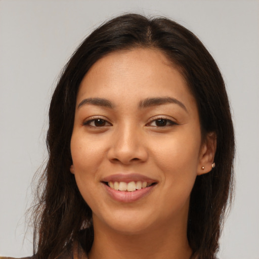 Joyful latino young-adult female with long  brown hair and brown eyes