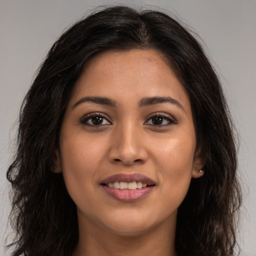 Joyful latino young-adult female with long  brown hair and brown eyes
