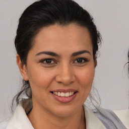 Joyful latino young-adult female with medium  brown hair and brown eyes