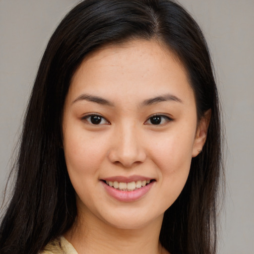 Joyful asian young-adult female with long  brown hair and brown eyes