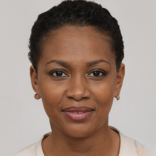 Joyful black young-adult female with short  black hair and brown eyes