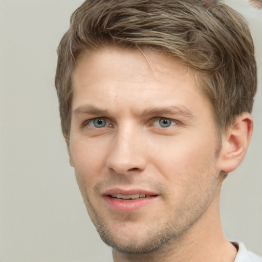 Joyful white young-adult male with short  brown hair and grey eyes