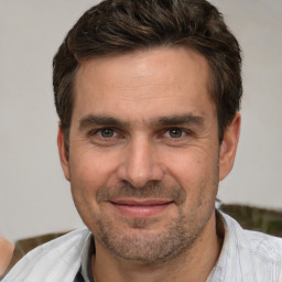 Joyful white adult male with short  brown hair and brown eyes