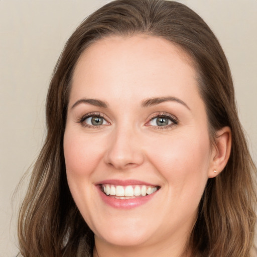 Joyful white young-adult female with long  brown hair and green eyes