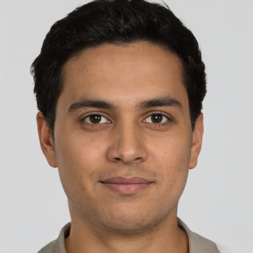 Joyful latino young-adult male with short  brown hair and brown eyes