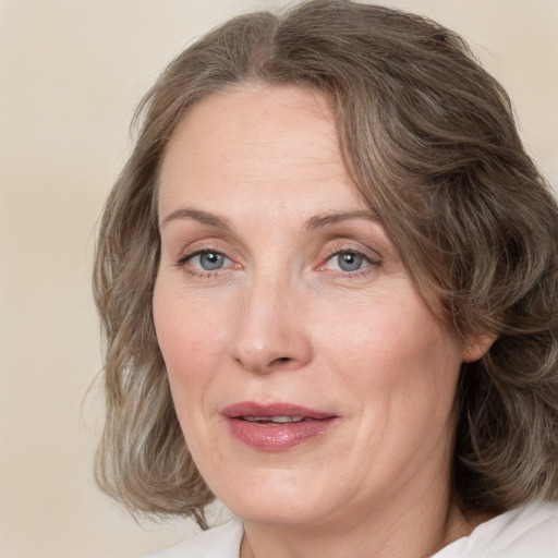 Joyful white adult female with medium  brown hair and blue eyes