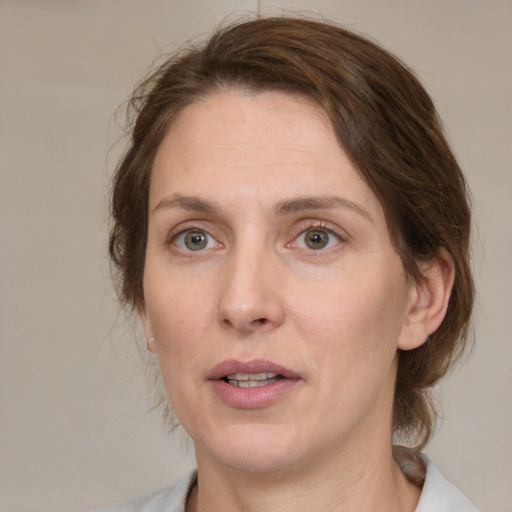 Joyful white adult female with medium  brown hair and grey eyes