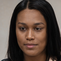 Joyful black young-adult female with long  brown hair and brown eyes