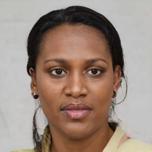 Joyful black young-adult female with short  brown hair and brown eyes