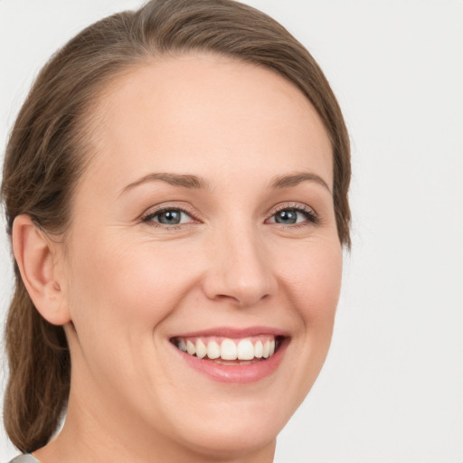 Joyful white young-adult female with medium  brown hair and green eyes