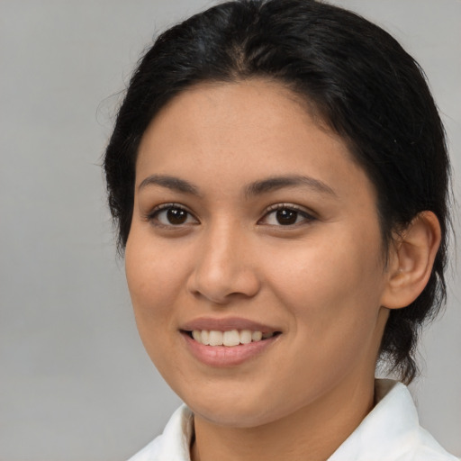 Joyful latino young-adult female with medium  brown hair and brown eyes