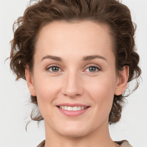 Joyful white young-adult female with medium  brown hair and green eyes