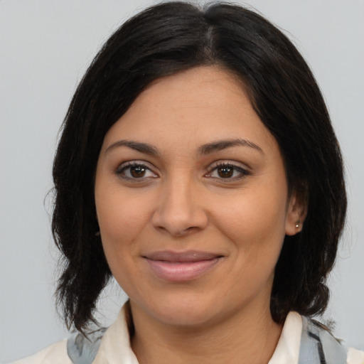 Joyful latino young-adult female with medium  brown hair and brown eyes