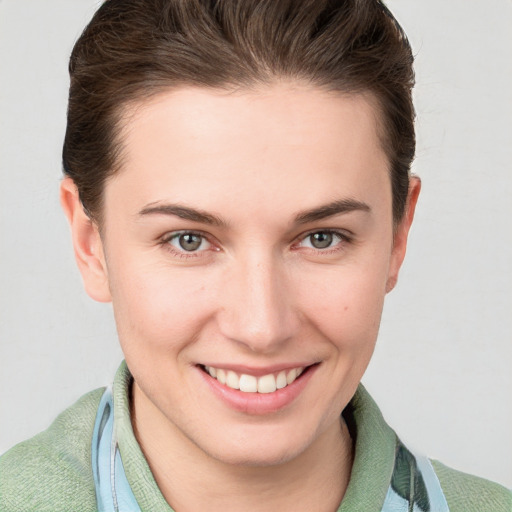 Joyful white young-adult female with short  brown hair and blue eyes