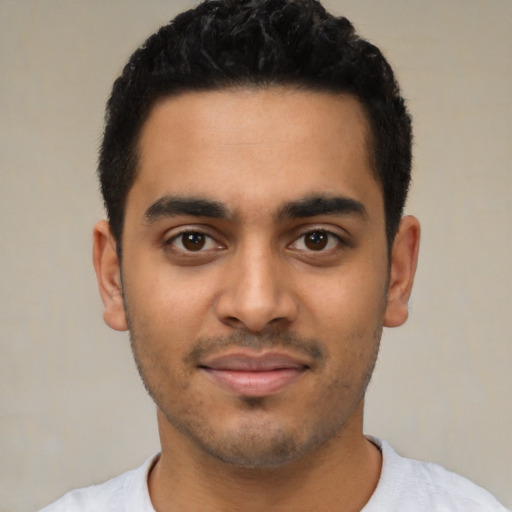 Joyful latino young-adult male with short  black hair and brown eyes