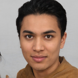 Joyful latino young-adult male with short  brown hair and brown eyes