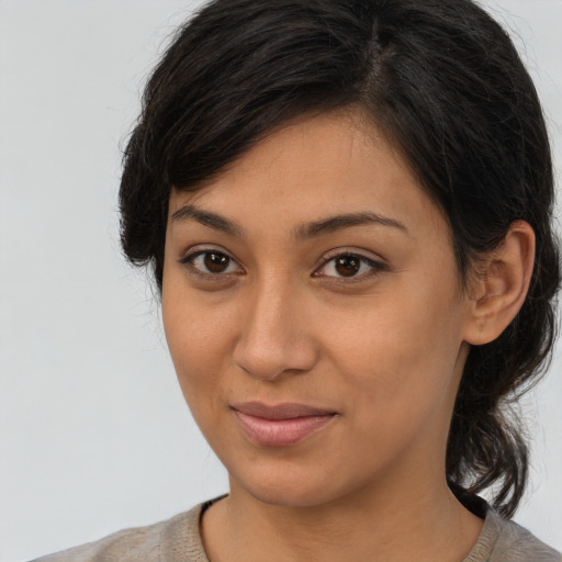 Joyful latino young-adult female with medium  brown hair and brown eyes