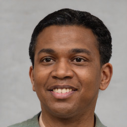 Joyful latino young-adult male with short  black hair and brown eyes